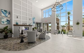 A large lobby with chairs and tables and a fireplace